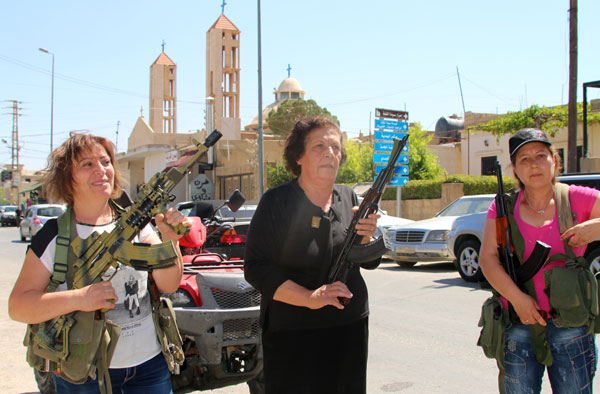 Lebanese Christian women hold weapons as residents of the Christian village of Qaa, near the Lebanon's border with war-ravaged Syria, secure the area on Tuesday after two waves of suicide bombings struck the village killing and wounding several people (AFP photo)
