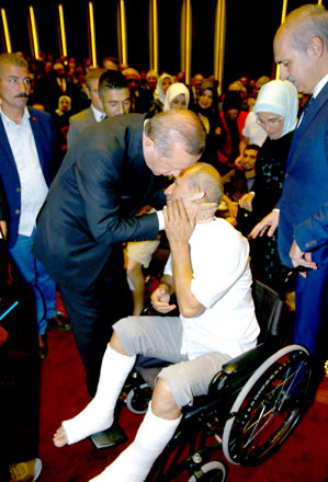 Turkey President Recep Tayyip Erdogan hugs a wounded civilian during an event to comment on those killed and wounded during a failed July 15 military coup in Ankara, Turkey, late Friday (AP photo)