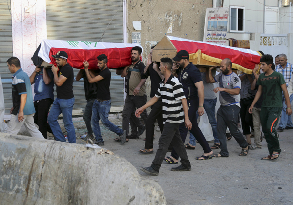 Mourners carry the Iraqi flag-draped coffins of bomb victims during their funeral procession in Baghdad, Iraq, on Tuesday (AP photo)