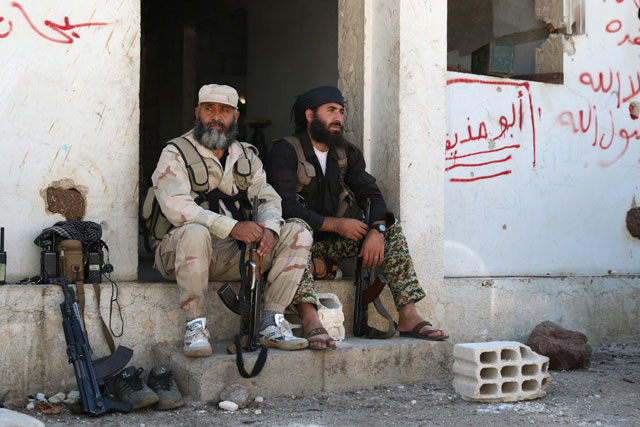 Rebel fighters rest with their weapons in Quneitra countryside, Syria, on Saturday (Reuters photo)