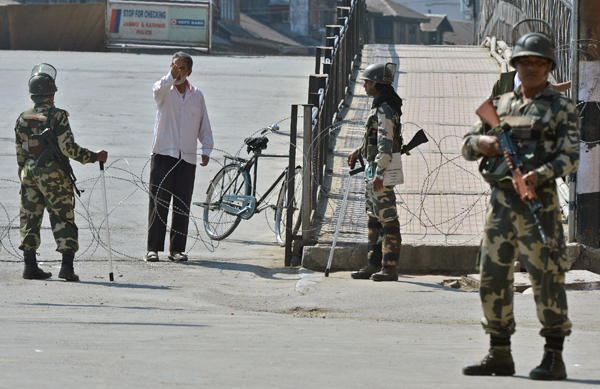 Indian paramilitary troopers stop a Kashmiri pedestrian as they stand guard during a curfew in the Lal Chowk area of central Srinagar on Monday (AFP photo)