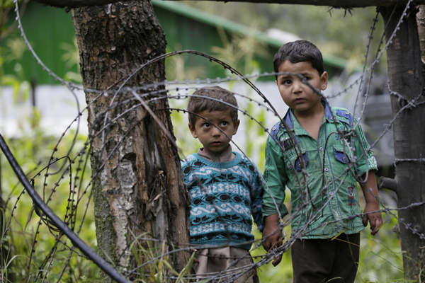 Kashmiri boys hold hands and walk near a military base at Braripora, near the de facto border dividing Kashmir between India and Pakistan, in Indian controlled Kashmir, on Wednesday (AP photo)