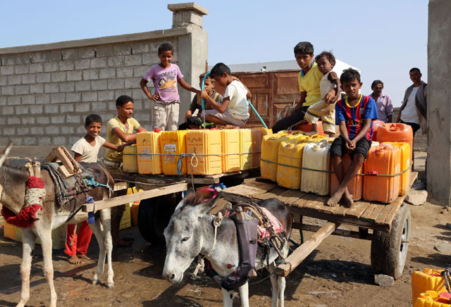 Yemeni children fill empty jerrycans with water from a donated source amid ongoing widespread disruption of water supplies in an impoverished coastal village on the outskirts of the Yemeni port city of Hodeidah on Tuesday (AFP photo)
