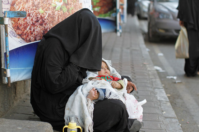 A woman begs along a street in Sanaa, Yemen, on Thursday (Reuters photo)