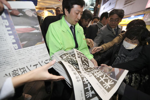 An employee distributes an extra edition of a newspaper reporting Donald Trump’s victory at the US presidential election, in Tokyo, on Wednesday (AP photo)