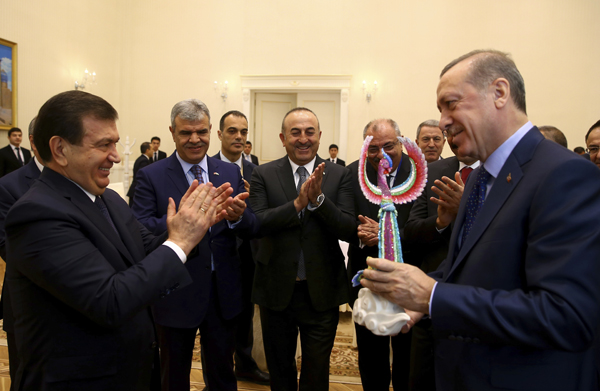 Turkey’s President Recep Tayyip Erdogan (right) receives a souvenir from Uzbek President Shavkat Mirziyoyev (left) as they visit a hand-works market in Samarkand, Uzbekistan, on Friday (AP photo)