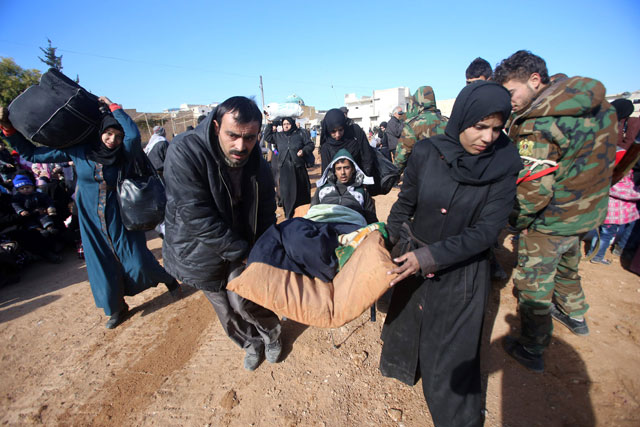Syrian residents fleeing the violence gather at a checkpoint, manned by pro-government forces, in the village of Aziza on the southwestern outskirts of the northern Syrian city of Aleppo on Thursday (AFP photo)