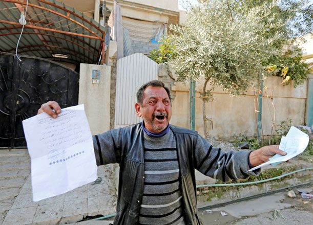 Abu Wissam, whose wife and son were killed by Daesh militants, cries as he holds up the militants’ execution order for his son, east of Mosul, Iraq, on Wednesday (Reuters photo by Ahmed Saad)