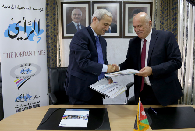 Jordan Press Foundation Chairman Ayman Majali and Al Noor Printing Press General Manager Muhammad Abbasi (left) shake hands during the signing ceremony on Tuesday (JT photo)