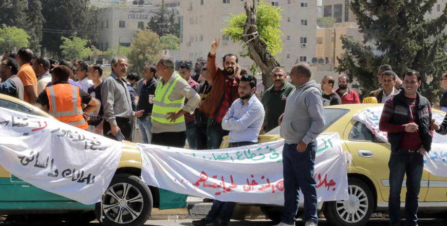 Taxi drivers protest the implementation of ride-hailing apps in front of Parliament   in April last year (Photo by Osama Aqarbeh)