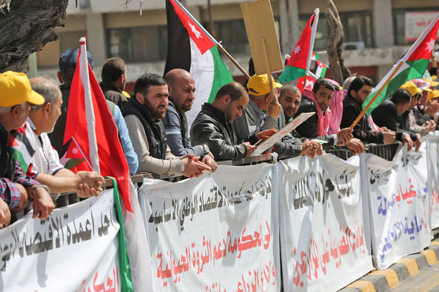 Farmers stand outside Parliament protesting against the recent government’s decision to increase taxes in Amman on Monday (Photo by Osama Aqarbeh)