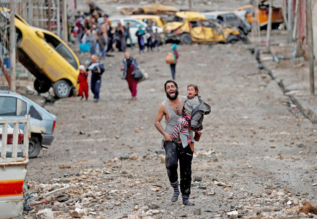 A man cries as he carries his daughter while walking from a Daesh-controlled part of Mosul towards Iraqi special forces soldiers during a battle in Mosul, Iraq, on March 4 (Reuters photo)