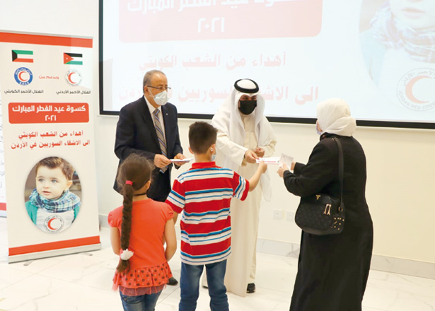 The Jordan National Red Crescent Society and the Kuwaiti Red Crescent distribute ‘Eid clothing’ cards to Syrian families (Photo courtesy of Petra)