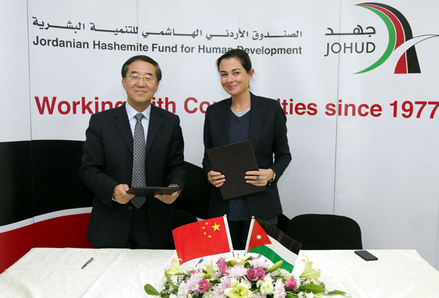 Chinese Ambassador to Jordan Pan Weifang and Jordanian Hashemite Fund for Human Development Executive Director Farah Daghistani hold documents signed on Tuesday as part of a memorandum of understanding (Petra photo)