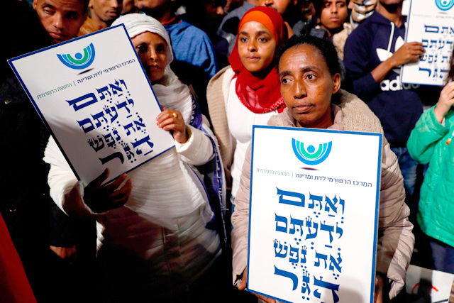 African migrants hold signs reading in Hebrew ‘You come from the Bible, you too are refugees’, during a demonstration in the Israeli coastal city of Tel Aviv on Saturday, against the Israeli government's policy to forcibly deport African refugees and asylum seekers to Rwanda and Uganda (AFP photo)