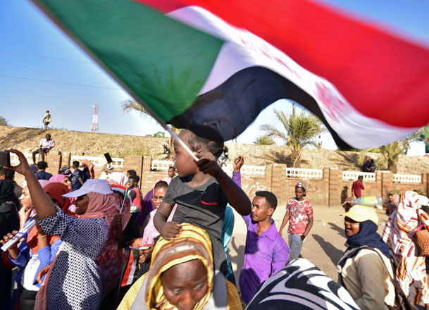   A young Sudanese boy waves a national flag as people celebrate after an announcement made by Sudan's new military ruler, in the Sudanese capital Khartoum, on Saturday (AFP photo)