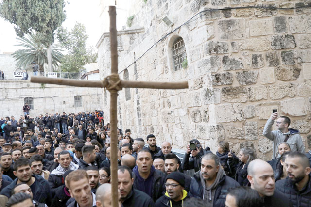 Worshippers hold a cross during a protest in front of the closed doors of the Church of the Holy Sepulchre in Jerusalem’s Old City on Tuesday (Reuters photo)