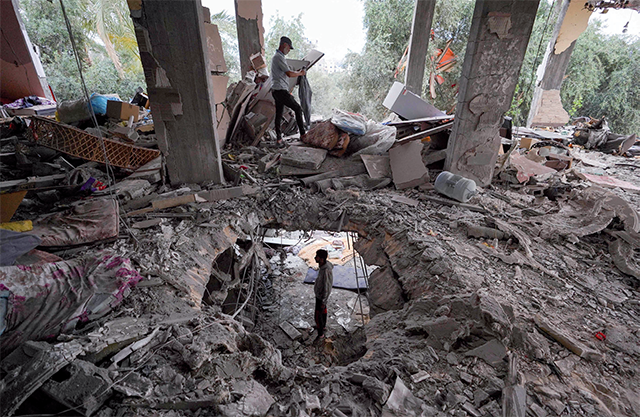 Palestinians inspect the damage to a house after it was hit in an Israeli strike in Al Bureij camp in the central Gaza Strip on Monday (AFP photo)