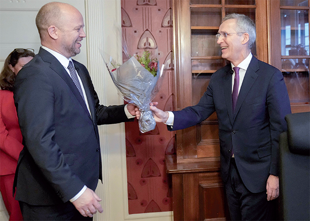 Norway’s outgoing Finance Minister Trygve Slagsvold Vedum hands a bouquet of flowers to his successor, former NATO Secretary General Jens Stoltenberg during a key handover ceremony, on Tuesday at the ministry of finance in Oslo (AFP photo)