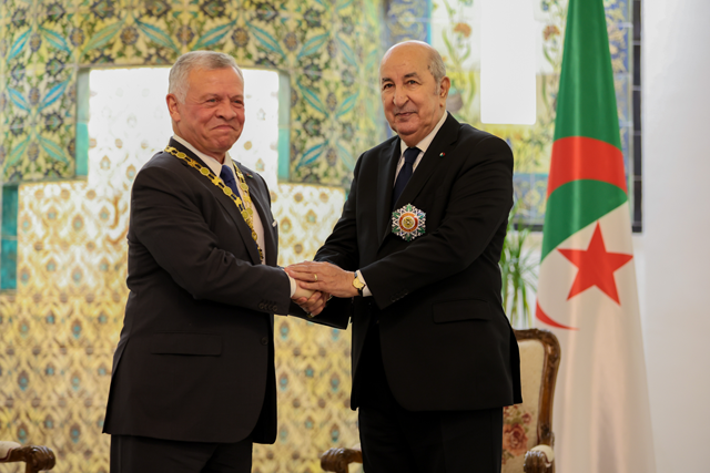 His Majesty King Abdullah bestows the Order of the Bejewelled Grand Cordon of Al Nahda (Order of the Renaissance) on Algerian President Abdelmadjid Tebboune, who presents the Medal of National Order of Merit 'Athir' to His Majesty, in Algiers, on Saturday (Photo courtesy of Royal Court)