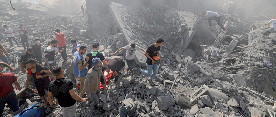 People search for survivors and the bodies of victims through the rubble of buildings destroyed during Israeli bombardment, in Khan Yunis in the southern Gaza Strip on Thursday (AFP photo)
