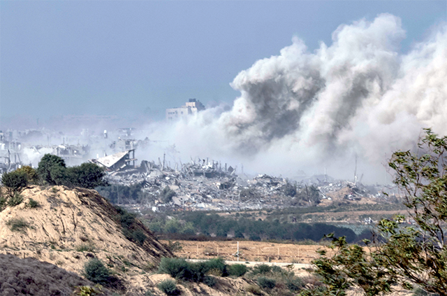 This photo taken from southern Israel shows smoke rising above buildings during an Israeli strike on the Gaza Strip on Monday (AFP photo)