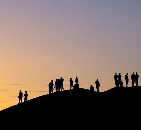 Palestinians are silhouetted against the setting sun as they stand on a hill on the Gaza-Egypt border in Rafah, on the southern Gaza Strip, on Tuesday, amid the ongoing Israeli war on the strip (AFP photo)