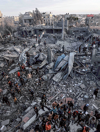Palestinians stand amidst the rubble of a mosque and buildings which collapsed during Israeli bombardment around the town city of Rafah southern Gaza Strip on Monday (AFP photo)