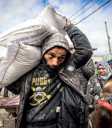 Displaced Palestinians receive food aid at the United Nations Relief and Works Agency for Palestine Refugees (UNRWA) center in Rafah in the southern Gaza Strip on Sunday (AFP photo)