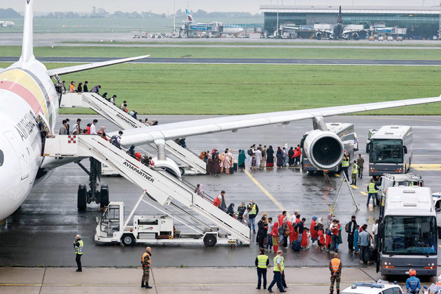 A group of Afghan nationals arrive on the tarmac after disembarking from a chartered Air Belgium airplane at the military airport in Melsbroek near Brussels on Monday (AFP photo)
