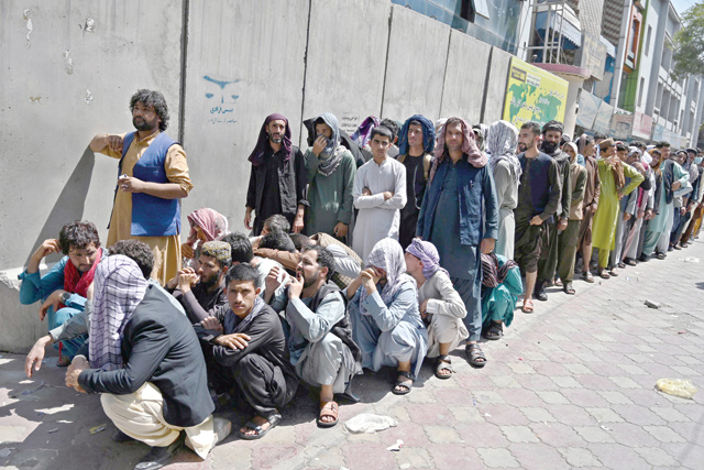 People stand on a queue outside a bank to withdraw money at Shar-e-Naw neighbourhood in Kabul on Saturday (AFP photo)