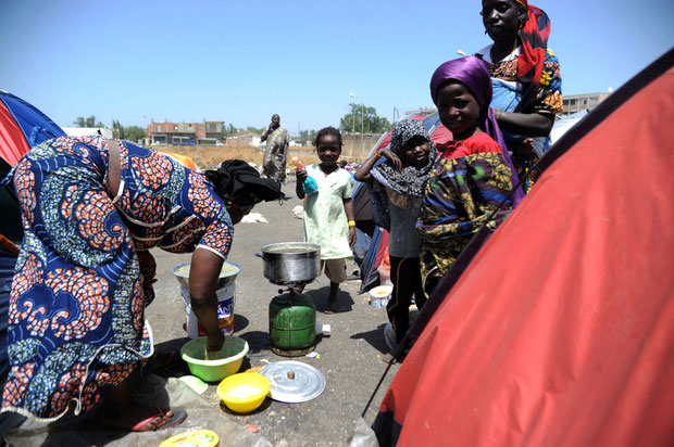 Migrants from Niger living near the marketplace in Boufarik, Algeria, cook food near their tents (AFP photo)