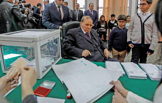 Algeria's President Abdelaziz Bouteflika signs after casting his vote during the local elections at a polling station in Algiers, Algeria, on Thursday (Reuters photo)