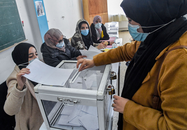 A woman casts her ballot while voting in the Algerian local elections at a polling station in the capital Algiers on Saturday (AFP photo)