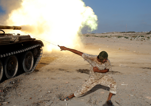 A fighter of Libyan forces allied with the UN-backed government fires a shell with Soviet made T-55 tank at Daesh militants in Sirte, Libya,  on Tuesday (Reuters photo)