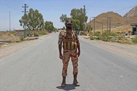 A security personnel stands guard along a street near the site of a school bus bombing in the Khuzdar district of Balochistan province on May 21, 2025 (AFP photo)