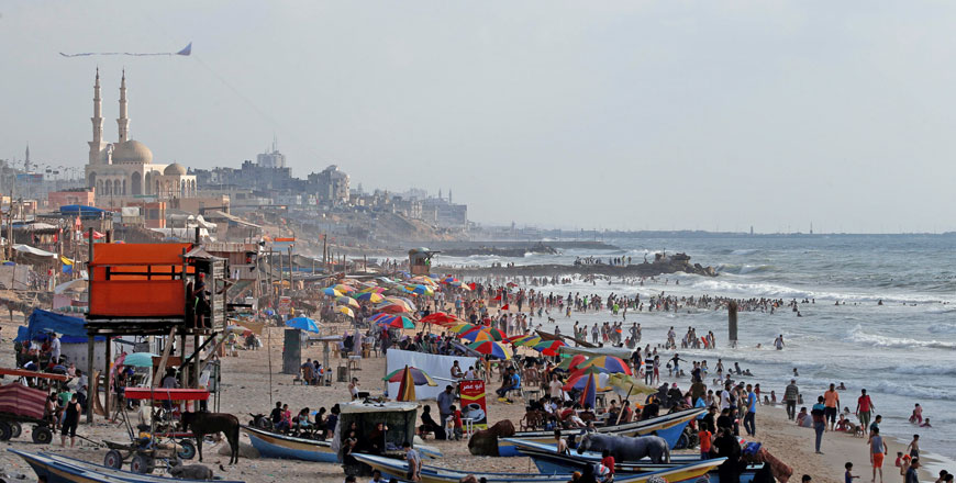 Palestinians swim to cool off in the Mediterranean Sea as others enjoy their time on a beach in the northern Gaza Strip on Friday (Reuters photo)