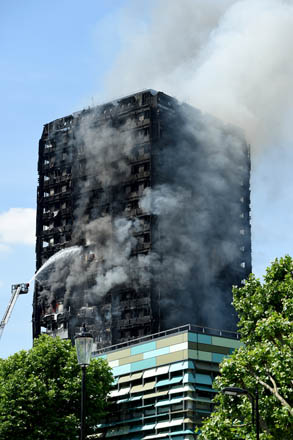 Smoke rises from the building after a huge fire engulfed the 24 storey residential Grenfell Tower block in Latimer Road, West London, in the early hours of this morning on Wednesday (Anadolu Agency photo)