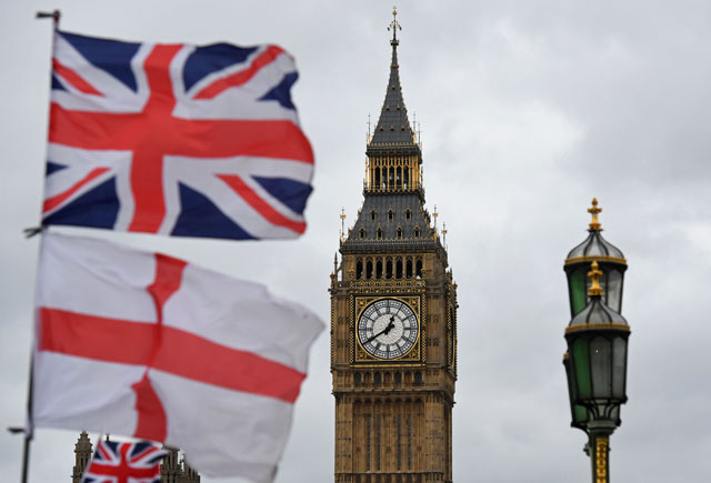 A Union flag flies above an English St. Georges Cross flag near the Big Ben clock face and the Elizabeth Tower at Houses of Parliament in central London on Wednesday (AFP photo)