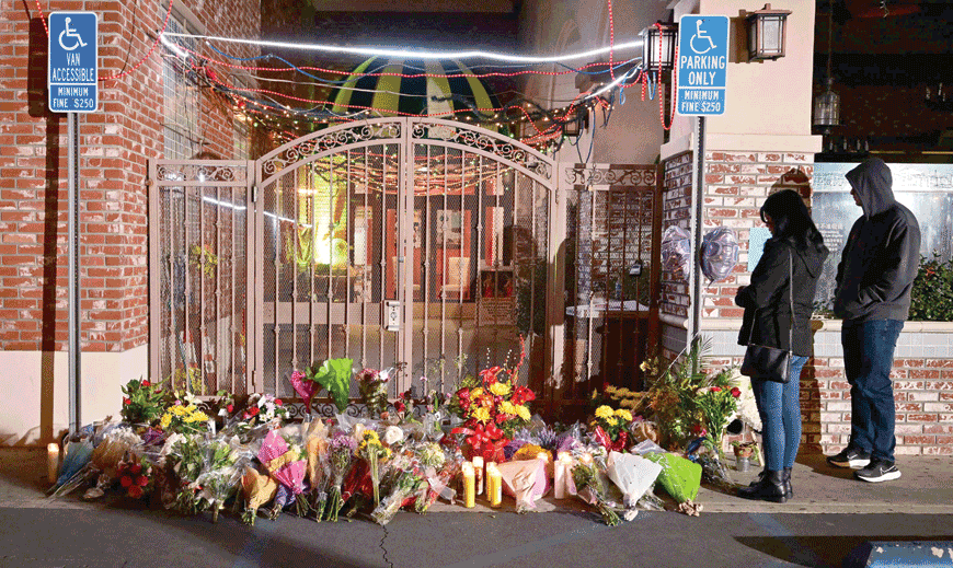People pay their respects in front of a makeshift memorial for victims of a mass shooting outside the Star Dance Studio in Monterey Park, California, on Monday (AFP photo)