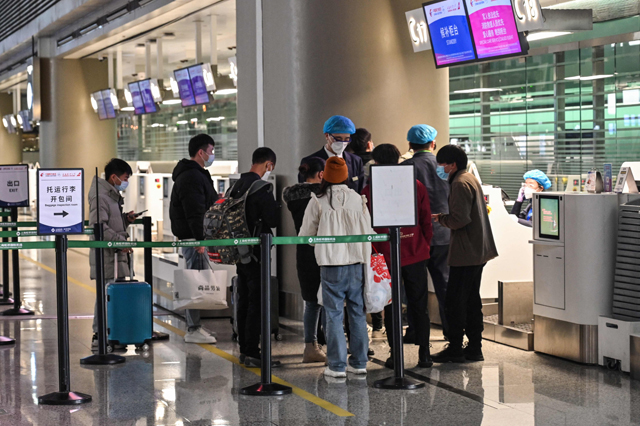 People stand at the check-in counters of China Eastern Airlines in Hongqiao International Airport in Shanghai on Monday (AFP photo)