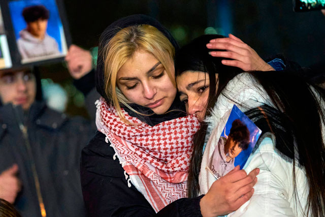 Mourners console each other during a vigil for the victims of Ukrainian Airlines flight 752 which crashed in Iran at Mel Lastman Square in Toronto, Ontario, on Thursday (AFP photo)