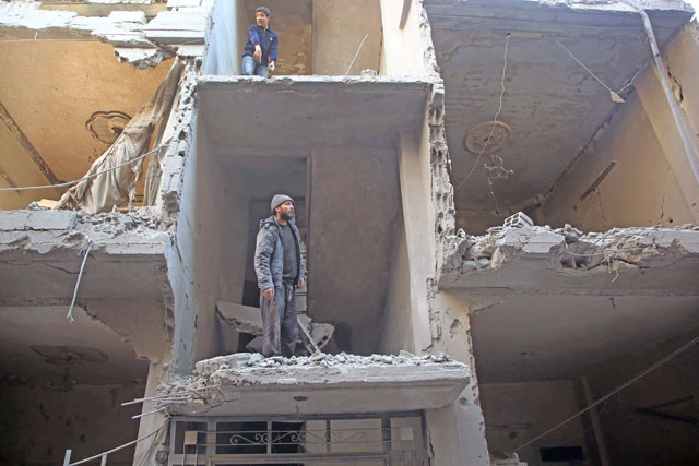 Syrians inspect the damage in a residential building hit in air strikes by regime forces on Arbin, in the rebel-held Eastern Ghouta region on the outskirts of the Syrian capital Damascus, on Thursday (AFP photo)