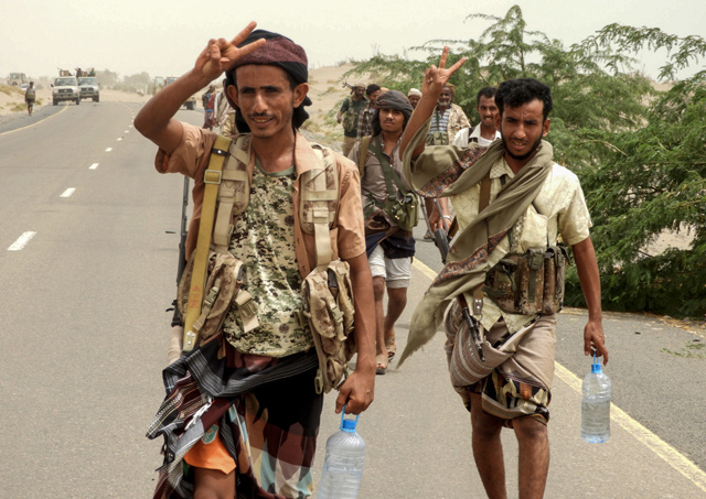 Yemeni pro-government forces flash the victory gesture as they arrive in Al Durayhimi district, about 9 kilometres south of Hodeidah International Airport, on Wednesday (AFP photo)