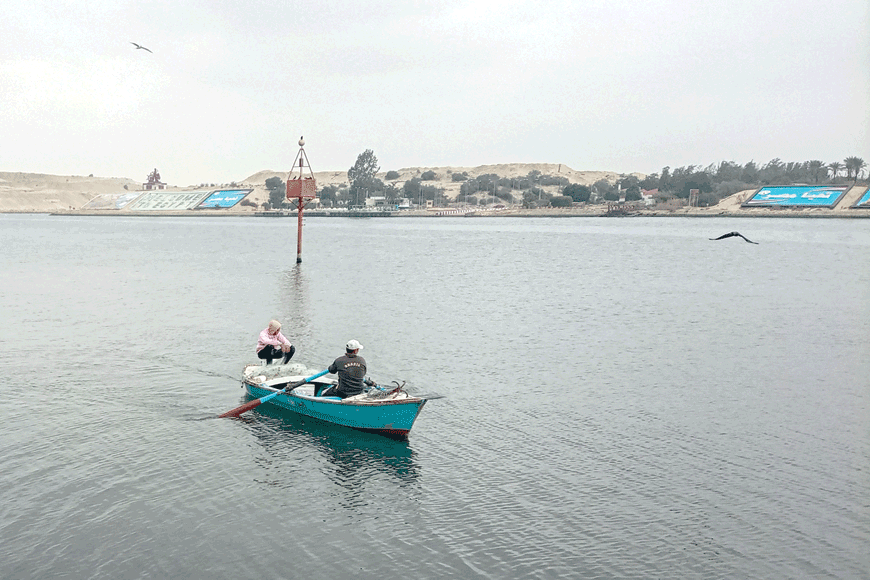 Fishermen sit in a boat in the Suez Canal near Ismailia in eastern Egypt on Monday (AFP photo)