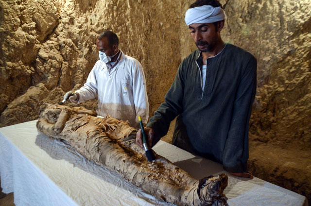 Egyptian archaeological technicians restore a mummy wrapped in linen, found at the newly discovered ‘Kampp 150’ tomb at Draa Abul Naga necropolis on the west Nile bank of the southern Egyptian city of Luxor, south of the capital Cairo, on Saturday (AFP photo)