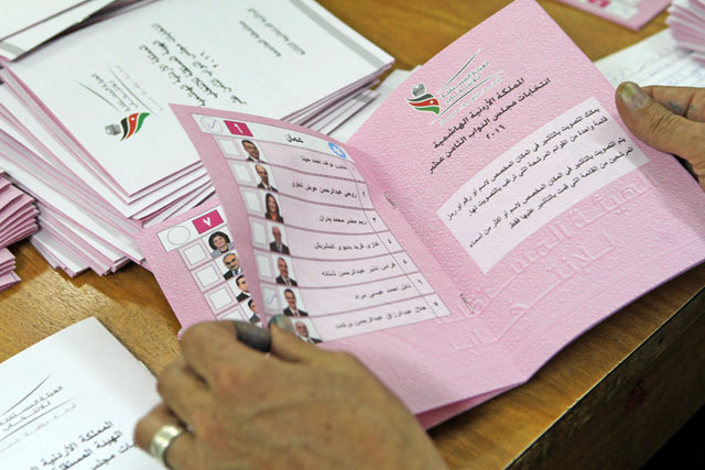 An election official holds a ballot as the vote counting continues in the parliamentary elections on Wednesday (Photo by Nader Daoud)