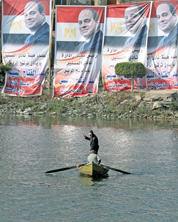 An Egyptian man rows a boat at the Nile River in front of posters depicting Egypt's President Abdel Fattah Al Sisi for presidential elections that reads ‘we've chosen you for a second term’, in the town of El Mansoura in the delta north of Cairo, Egypt, on Saturday (Reuters photo)