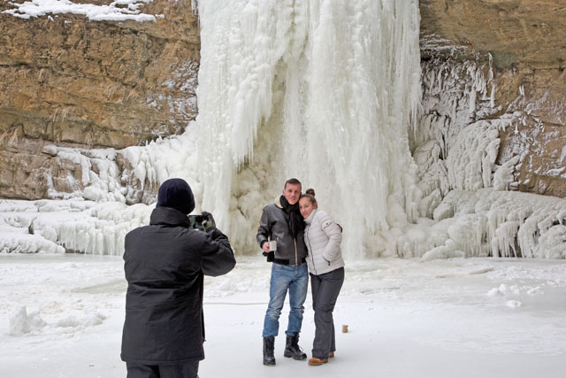 Visitors pose for a picture in front of the frozen Mirusha waterfalls near the village of Lapceve, Kosovo, Monday (AP photo)