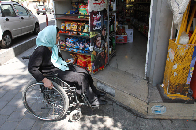 Iranian Fatemeh Nikbakht, who lost the use of her legs in an accident in the 1990s and today runs the Spinal Cord Injury Association, waits outside a store with no ramp for wheelchair access on August 1 in Tehran (AFP photo)